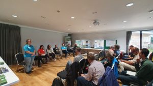 Panel of people at the front of a room during a conference.