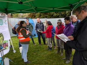 Photo of people under a gazebo listening to a talk