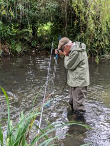 Photo of man in river monitoring flow